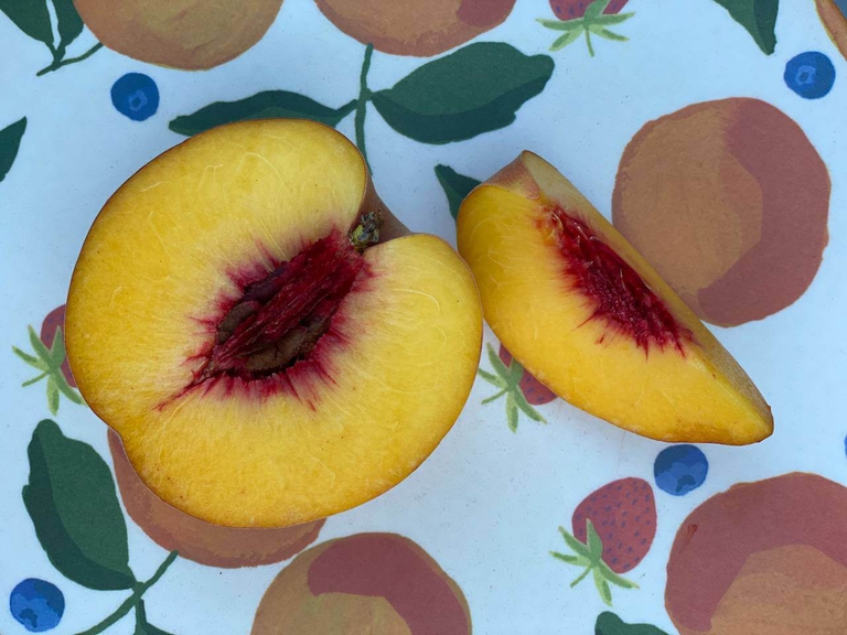 Inside view of a freestone Bennett Peach with a yellow flesh and separates easily from the pit. 